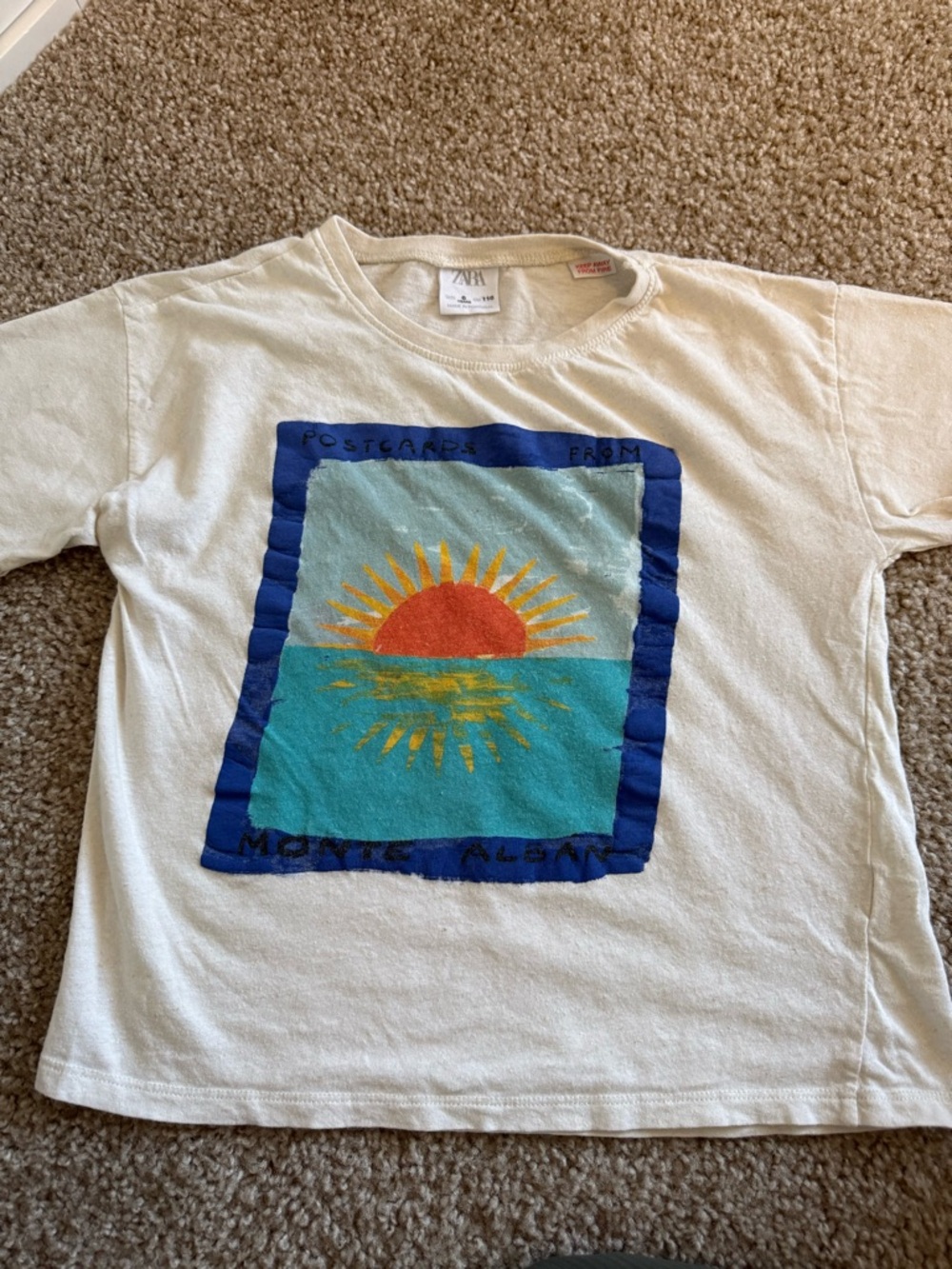 Zara Cream Tee with Blue Frame and Orange Sun Graphic